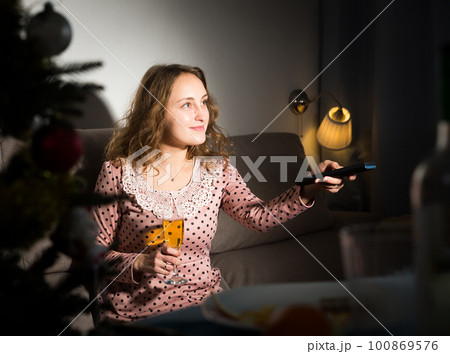 Smiling woman watching tv Smiling woman watching tv 100869576