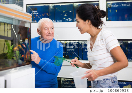 Old man choosing fish in pet shop 100869938