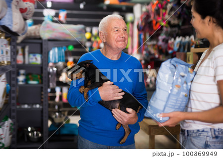 Senior man choosing dog food in pet shop Senior man choosing dog food in pet shop 100869949