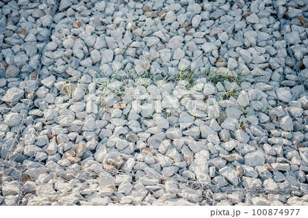 Granite stones behind a metal grate for strengthening the slope. Stones behind the wire. grey texture. construction. 100874977