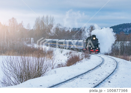 Retro steam train moves at winter morning time. 100877366