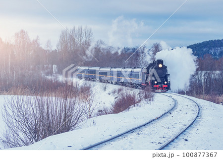Retro steam train moves at winter morning time. 100877367