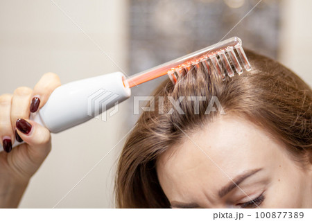 Woman uses darsonval for massage head's skin. Receiving electric darsonval facial massage procedure. Face Beauty Treatment. Darsonval Therapy Using High Frequency D'Arsonval, Skin Care Device . Woman uses darsonval for massage head's skin. Receiving electric darsonval facial massage procedure. Face Beauty Treatment. Darsonval Therapy Using High Frequency D'Arsonval, Skin Care Device . 100877389