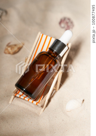 Summer sunscreen essence in deck chair on the sand backgroundwith shells ans seastar. B 100877495