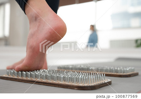 A woman comes down from the sadhu boards. Close-up of feet with prints after nails.  100877569
