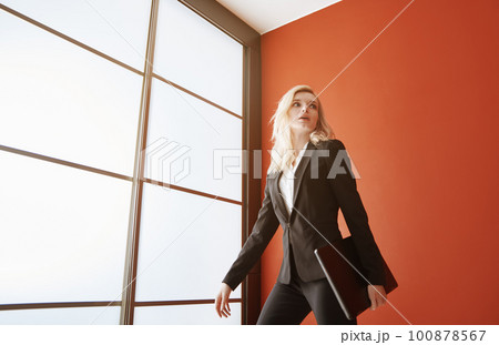 Young adult business woman wearing formalwear and carrying the laptop 100878567
