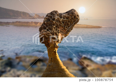 The sun is gradually moving towards sea level. Factory silhouette at sunset. 100878754