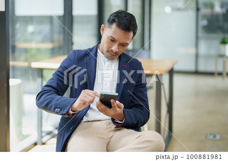 Portrait of a male business owner using a mobile phone. 100881981