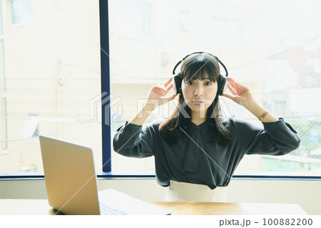 オフィスでノートパソコンを使っている若い女性 オフィスでノートパソコンを使っている若い女性 100882200