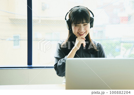 オフィスでノートパソコンを使っている若い女性 100882204
