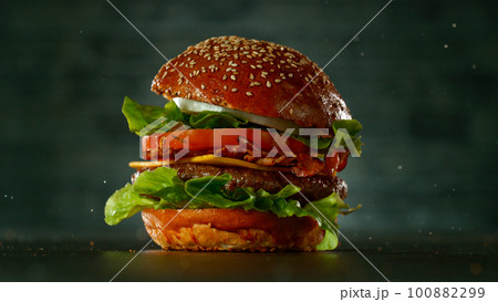 Tasty beef burger on black stone table, close-up Tasty beef burger on black stone table, close-up 100882299