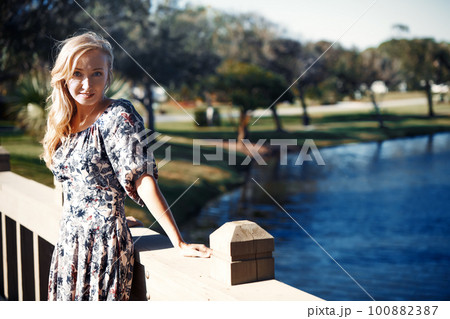 Smiling woman on the wooden bridge 100882387