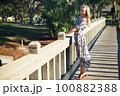Smiling woman on the wooden bridge 100882388