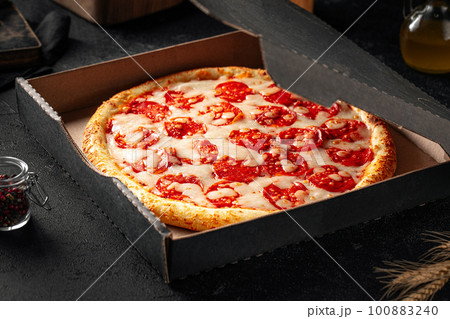 Take away packed pepperoni pizza with salami 100883240
