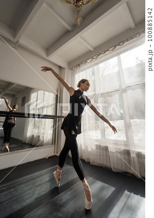 A beautiful Asian ballerina is training in a dance class. Vertical photo. 100885142