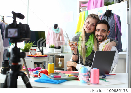 Happy smiling man and woman fashion designer stylists at workplace in atelier Happy smiling man and woman fashion designer stylists at workplace in atelier 100886138