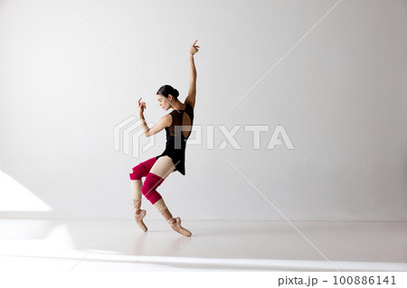 Photo of gorgeous ballerina wearing pointe shoes dancing on fingertips over white background Photo of gorgeous ballerina wearing pointe shoes dancing on fingertips over white background 100886141
