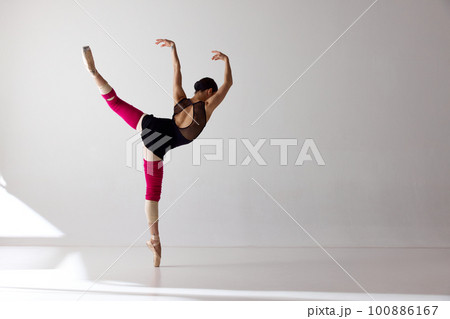 Back view of tender professional ballerina dancing in black bodysuit isolated over white background Back view of tender professional ballerina dancing in black bodysuit isolated over white background 100886167