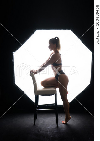 Silhouette of a beautiful young woman wearing underwear in backlight Silhouette of a beautiful young woman wearing underwear in backlight 100889408