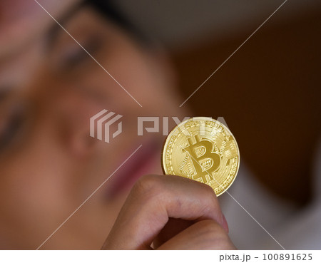 ビットコインを手に持つ ビットコインを手に持つ 100891625