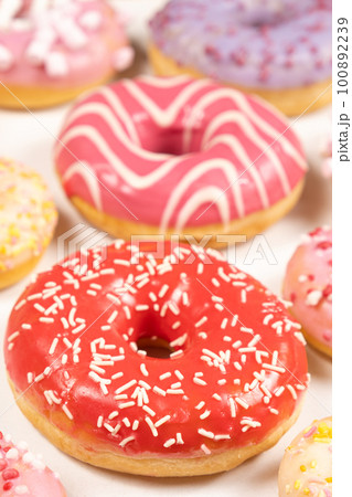 Donuts with red and pink glaze, top view. Lots of donuts, sweet and delicious food 100892239
