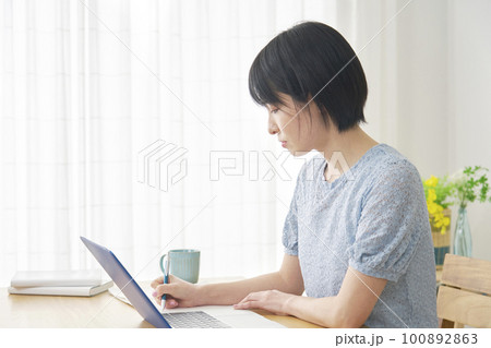 自宅でノートパソコンを使って勉強する女性 自宅でノートパソコンを使って勉強する女性 100892863