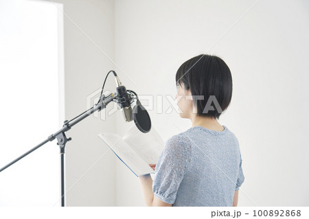スタジオでアフレコする女性声優 100892868
