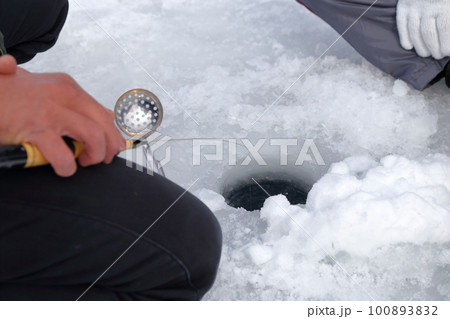 氷の穴に糸を垂らし当たりを待つ釣り人(ワカサギ釣り 松原湖 長野県 小海町) 氷の穴に糸を垂らし当たりを待つ釣り人(ワカサギ釣り 松原湖 長野県 小海町) 100893832