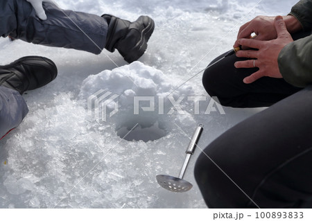 氷の穴に糸を垂らし当たりを待つ釣り人（ワカサギ釣り　松原湖　長野県 小海町） 100893833