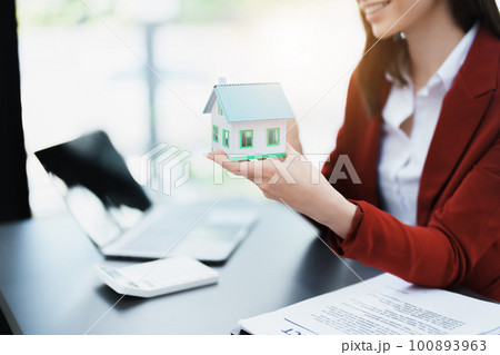 Guarantee, mortgage, agreement, contract, sign, real estate agent delivers the house to the customer after signing important contract documents. Guarantee, mortgage, agreement, contract, sign, real estate agent delivers the house to the customer after signing important contract documents. 100893963