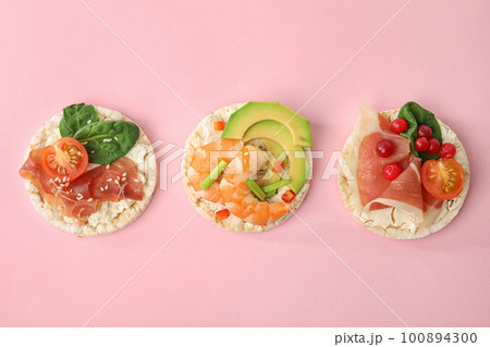 Puffed rice cakes with different toppings on pink background, flat lay Puffed rice cakes with different toppings on pink background, flat lay 100894300