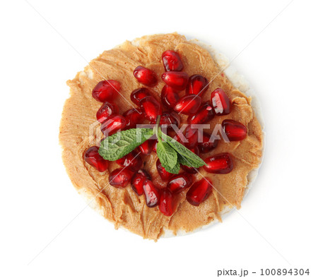 Puffed rice cake with peanut butter, pomegranate seeds and mint isolated on white, top view Puffed rice cake with peanut butter, pomegranate seeds and mint isolated on white, top view 100894304