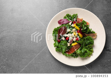 Tasty fresh kale salad on grey table, top view. Space for text Tasty fresh kale salad on grey table, top view. Space for text 100894353