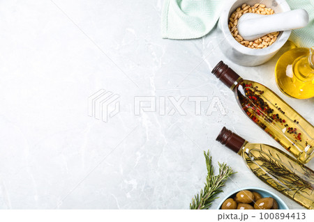 Flat lay composition with different sorts of cooking oil on grey marble table. Space for text Flat lay composition with different sorts of cooking oil on grey marble table. Space for text 100894413