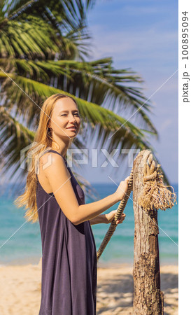 Vacation on tropical island. Woman in hat enjoying sea view from wooden bridge Vacation on tropical island. Woman in hat enjoying sea view from wooden bridge 100895094