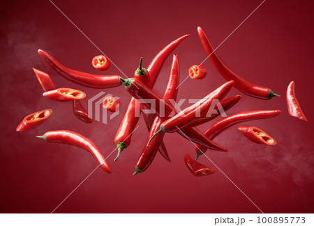 Steaming red pepper in motion on a red background. Steaming red pepper in motion on a red background. 100895773
