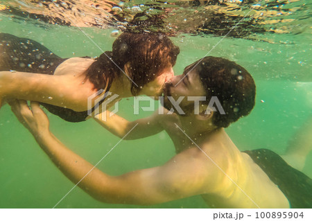 Man and Woman kissing underwater in the sea Man and Woman kissing underwater in the sea 100895904