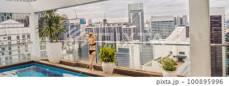 Young woman in the pool among the skyscrapers and the big city. Relax in the big city. Rest from stress BANNER, LONG FORMAT 100895996