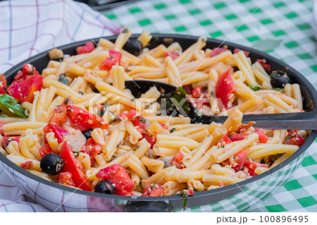 Fresh pasta with tomato and olives on counter - close up Fresh pasta with tomato and olives on counter - close up 100896495