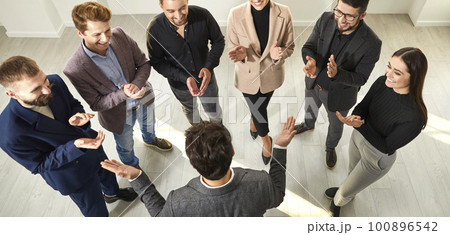 Banner with business team showing recognition to young man, clapping hands and smiling 100896542