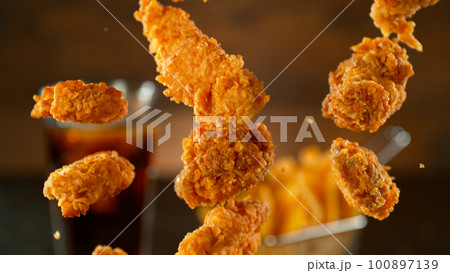 Freeze Motion Shot of Flying Fresh Fried Chicken Wings or Strips, Close-up 100897139