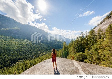 Hiking woman reaching amazing viewpoint on famous Squamish Stawamus Chief Mountain Hike in British Columbia nature landscape. Popular outdoor activity destination in Canada 100900925