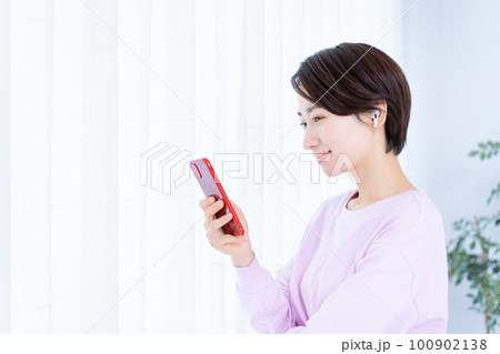 スマホで音楽を聴くミドルの女性 100902138