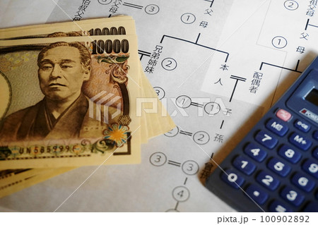 等親図の上に置かれた一万円札と電卓、相続イメージ 等親図の上に置かれた一万円札と電卓、相続イメージ 100902892