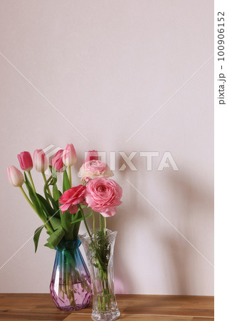 ガラスの花瓶に挿したチューリップとラナンキュラス 100906152