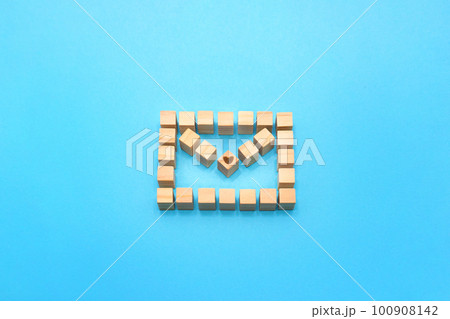 メールのアイコンの立体的なウッドキューブのフレームの中心にハートマークがある青い背景 メールのアイコンの立体的なウッドキューブのフレームの中心にハートマークがある青い背景 100908142