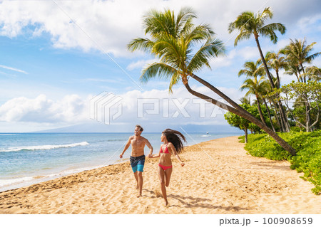 Happy Hawaii beach fun young people running enjoying summer vacations in Maui, Kaanapali beach, USA travel lifestyle 100908659