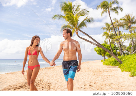 Hawaii beach vacation couple walking happy on Kaanapali beach, Maui, Hawaii, USA. Two people man, Asian bikini woman relaxing on stroll famous hawaiian destination for summer travel holidays Hawaii beach vacation couple walking happy on Kaanapali beach, Maui, Hawaii, USA. Two people man, Asian bikini woman relaxing on stroll famous hawaiian destination for summer travel holidays 100908660