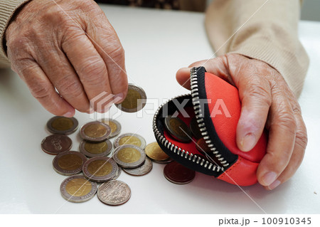 Retired elderly woman counting coins money and worry about monthly expenses and treatment fee payment. Retired elderly woman counting coins money and worry about monthly expenses and treatment fee payment. 100910345