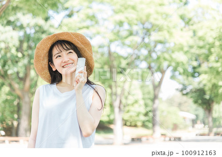 帽子を被って紫外線対策するアジア人女性（笑顔・日焼け止め） 100912163